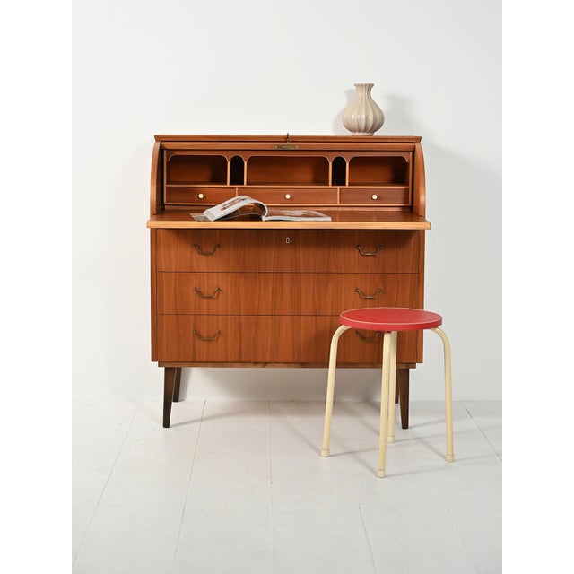 1950s Scandinavian teak secretary with refined oak inserts and legs with a contrasting dark finish. The pull-out top...
