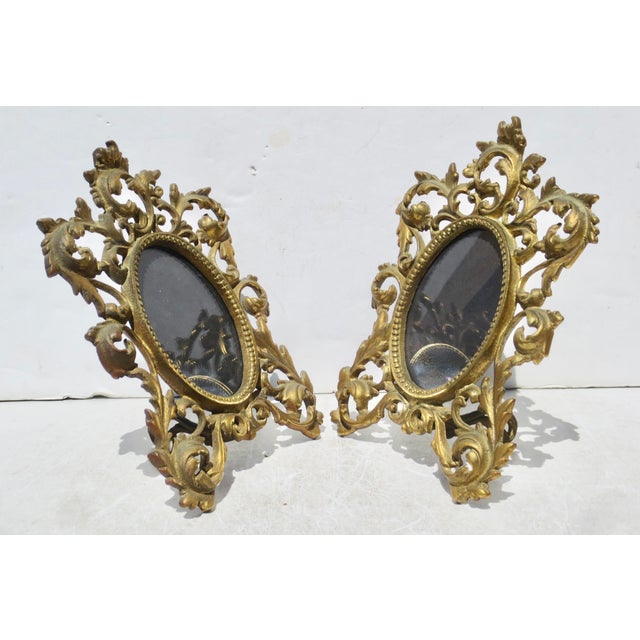 Matching pair of oval portrait frames. cast brass scrolling flourishes of acanthus designs. Facing glass and locking tabs...