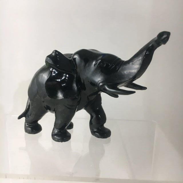 This elephant is carved from black nephrite jade which has been polished. The black stone has the faintest green hue...