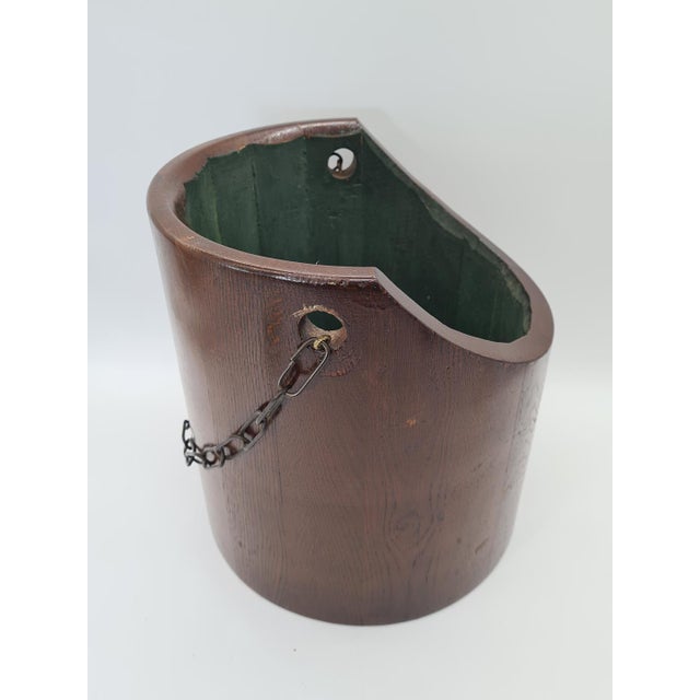 A decorative wooden hanging basket with a distinctive cylindrical shape, made of many carefully fitted wooden staves. The...
