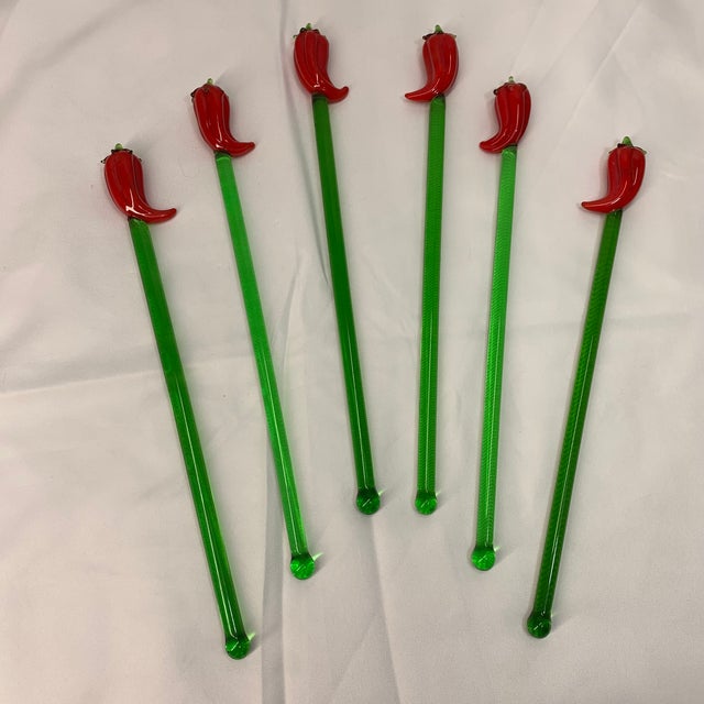 These are a set of vintage hand-blown green glass cocktail swizzle stir sticks featuring red chili pepper toppers.