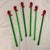 These are a set of vintage hand-blown green glass cocktail swizzle stir sticks featuring red chili pepper toppers.