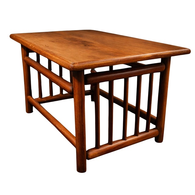 A striking mid-century modern coffee table crafted in warm, rich solid teak. Defined by its clean architectural lines,...