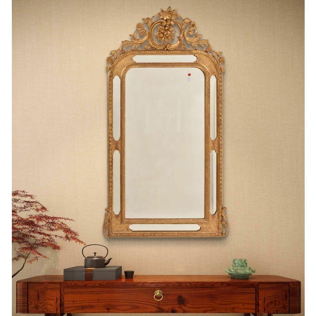 This beautiful Gilded Antique Mirror with a Neoclassical Crest, dating to the mid-19th century, is richly decorated with...