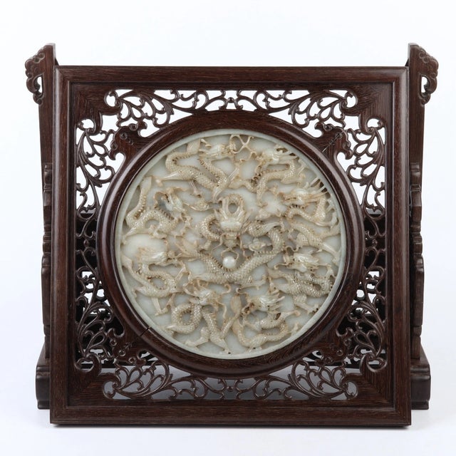 A captivating Chinese antique table screen featuring a magnificent, intricately carved jade central disc inlaid into a...