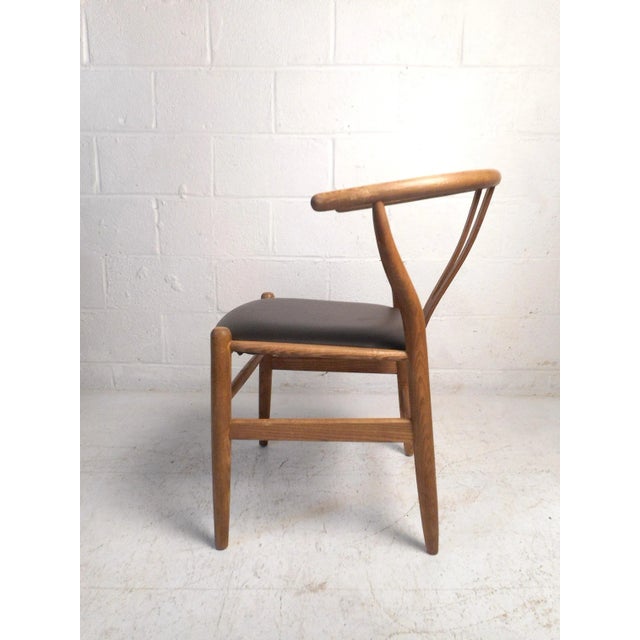 This impressive mid-century style chair is modeled after Hans Wegner's famous "Wishbone" design. Featuring a sturdy oak...
