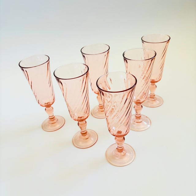 A set of 6 vintage champagne flutes in a pale blush pink hue. Each glass has a lovely swirl design. Made in France by...