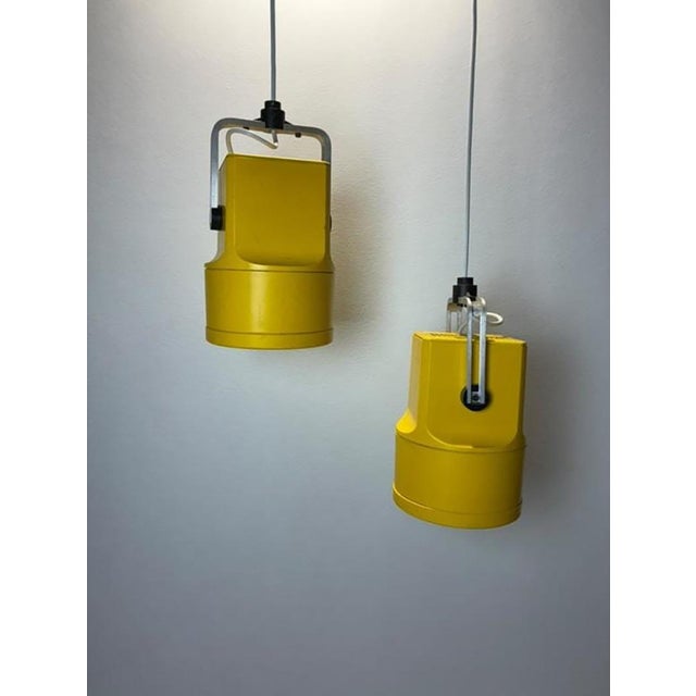 Iconic pair of 1970s danish unispot pendant lamps in vibrant mustard yellow. These adjustable spotlights embody the bold...