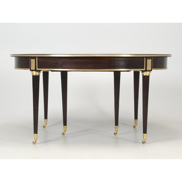 On first glance, one might misinterpret this mahogany dining table as just another 1940’s-1960’s veneer mahogany Louis XVI...