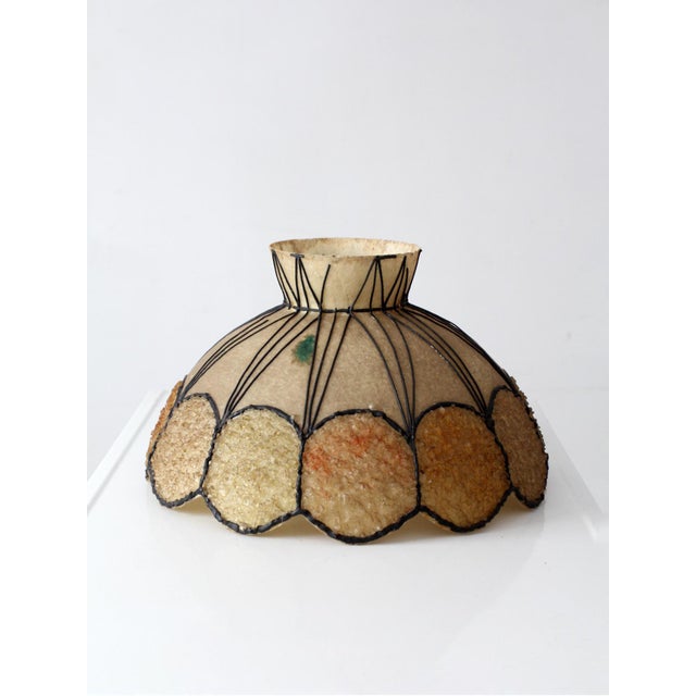 This vintage mid-century chandelier shade features a sculptural Atomic Age silhouette with black wire detailing over a...