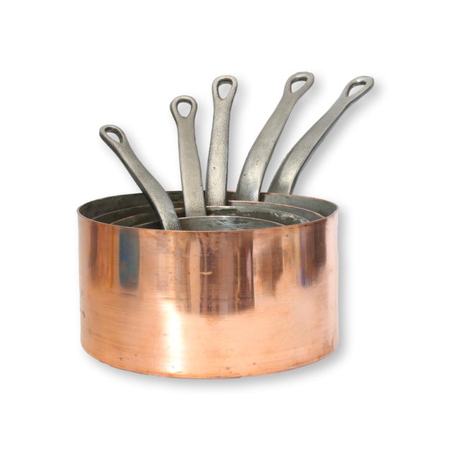 A handsome graduated set of antique French copper saucepans, crafted from thick-gauge copper with riveted iron handles for...