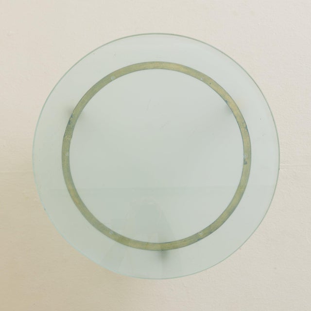A French low round coffee table from the 1960s, combining gilt metal and frosted glass. The circular frame rests on three...