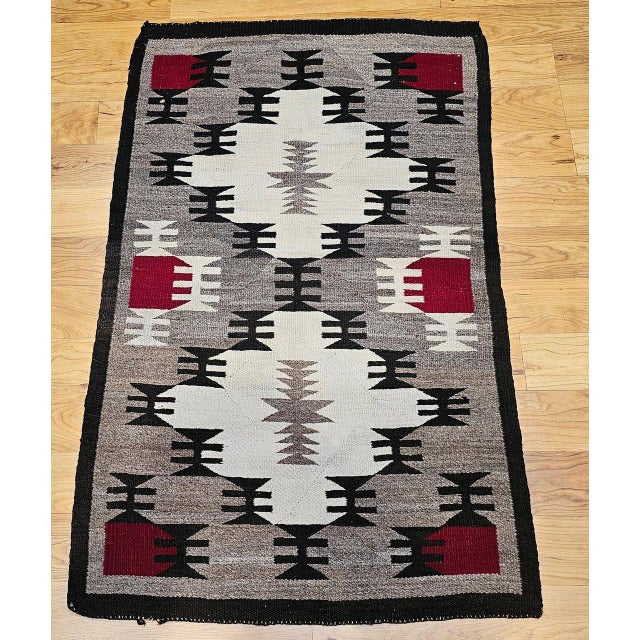An exceptional mid-20th century Navajo (Din�) textile from the American Southwest, this finely handwoven rug showcases the...