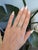 A bi-color tourmaline glows in shades of green and warm orange at the center of this emerald-cut ring, framed by a halo of...