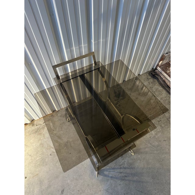 Arc-shaped chrome metal rolling bar trolley from the 70s. Smoked glass tops in perfect condition. Zipper system on the...