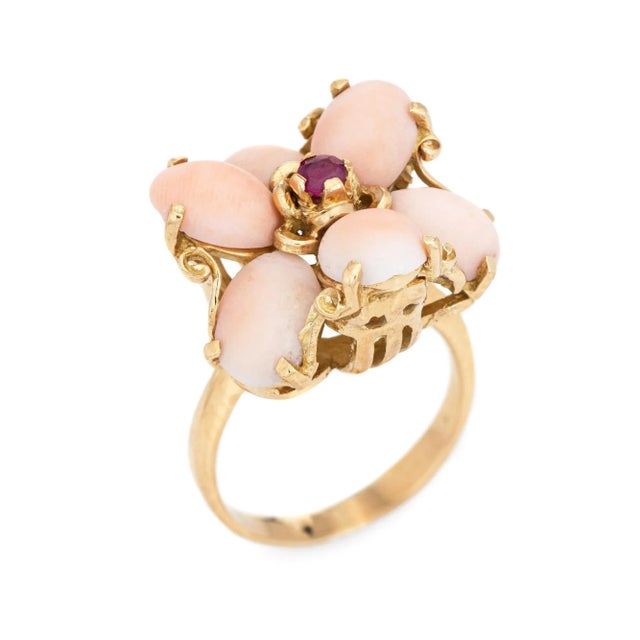 Stylish angel skin coral & ruby flower cocktail ring crafted in 18 karat yellow gold (circa 1970s). Cabochon cut coral...