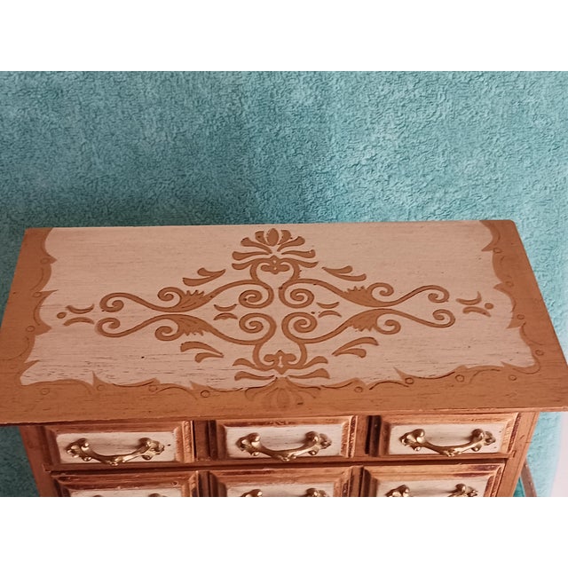 Florentine style jewelry chest consisting of 2 lower large drawers and 3 top small drawers. It is also a music box that...