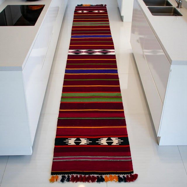 Woven in Central Anatolia (Konya region) in the 1990s, this long, narrow Turkish kilim runner brings a confident stripe...