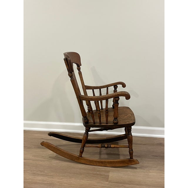 Antique, oak, early 20th century children’s rocking chair. A solid wood construction with carved details on the backrest...