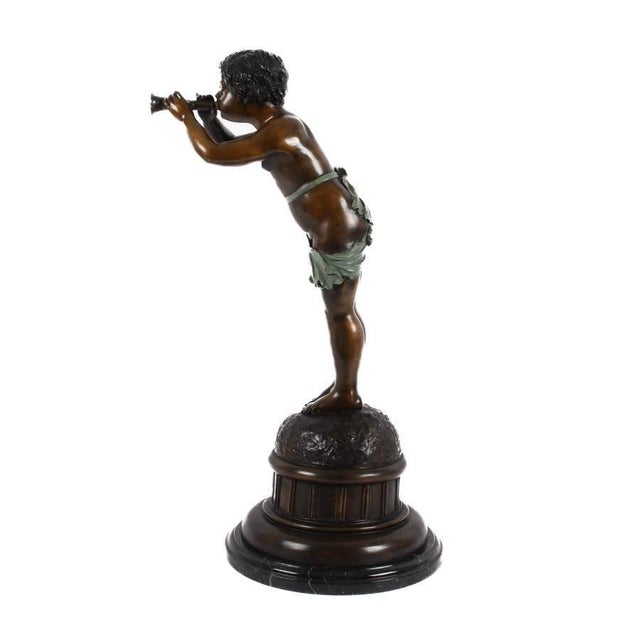This bronze sculpture depicts a youthful figure standing atop a naturalistic mound, holding a bugle to the lips in a...