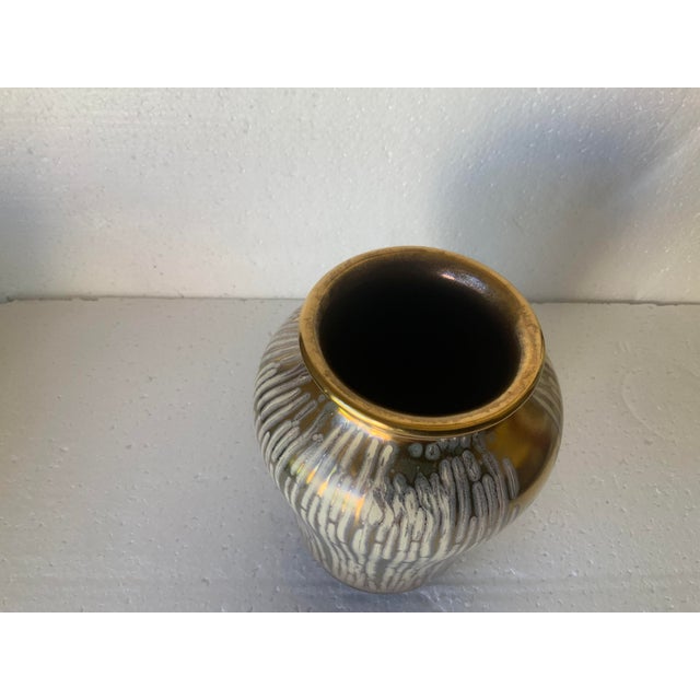 A classic example of mid century modern design; gold base with white drip overlay.