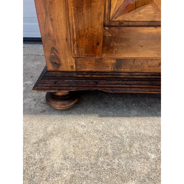 A charming Louis XIII-style 18th-century cabinet handcrafted from solid wood, featuring beautifully inlaid geometric...