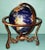 Very detailed desktop globe in a copper metal tripod created from semi precious stones set in resin, c. 1980s.