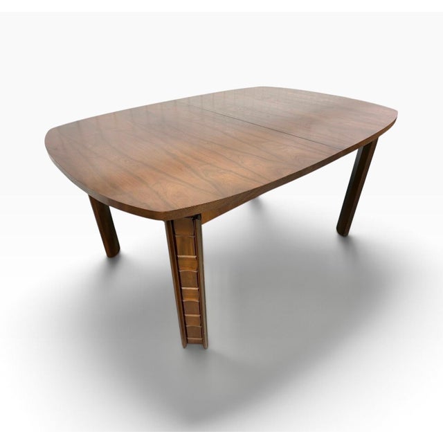 A striking Mid-Century Modern Brutalist walnut dining table, circa 1970s, featuring bold sculptural lines, substantial...