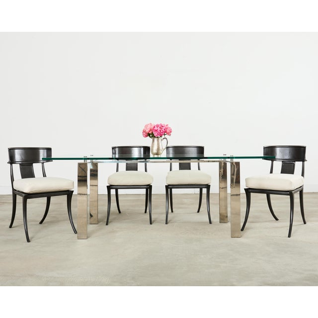 Dramatic set of four cast aluminum metal patio and garden dining chairs designed by Michael Taylor. The chairs feature an...