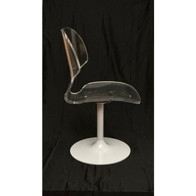 Single 1970s Vintage clear Lucite Acrylic swivel side /accent chair with white aluminum tulip base and stem. This chair...