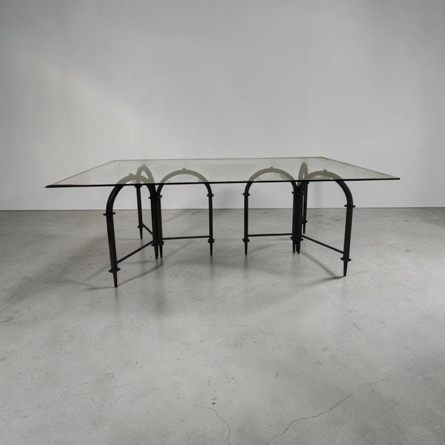 The Acquedotto Dining Table by Global Views features a dramatic architectural iron base inspired by the repeating arches...