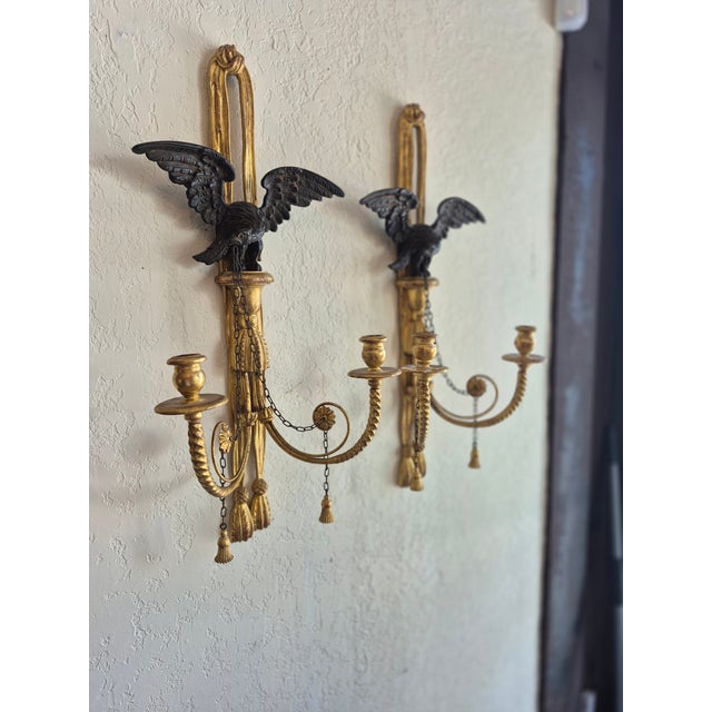 Standout pair of Italian parcel gilt carved wood two light wall scinces featuring eagles,chains,medallions and tassles.