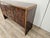 A 1950s Art Deco sideboard, crafted from fine walnut with elegant blond walnut inserts. This piece is striking for its...