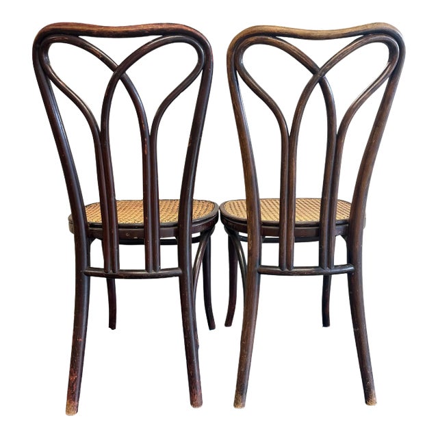 Pair of unique Bentwood Thonet Dining Chairs with cane seats. The delicate arches cross and connect at the rear loop...