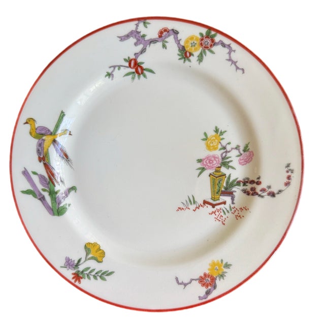 Elegant Chinoiserie themed luncheon plates by Jean Pouyat. Floral theme with red trim. Circa early 20th century.