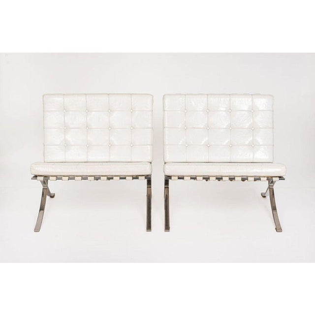 This pair of vintage mid century modern white Barcelona chairs designed by Mies van der Rohe were manufactured by Knoll...