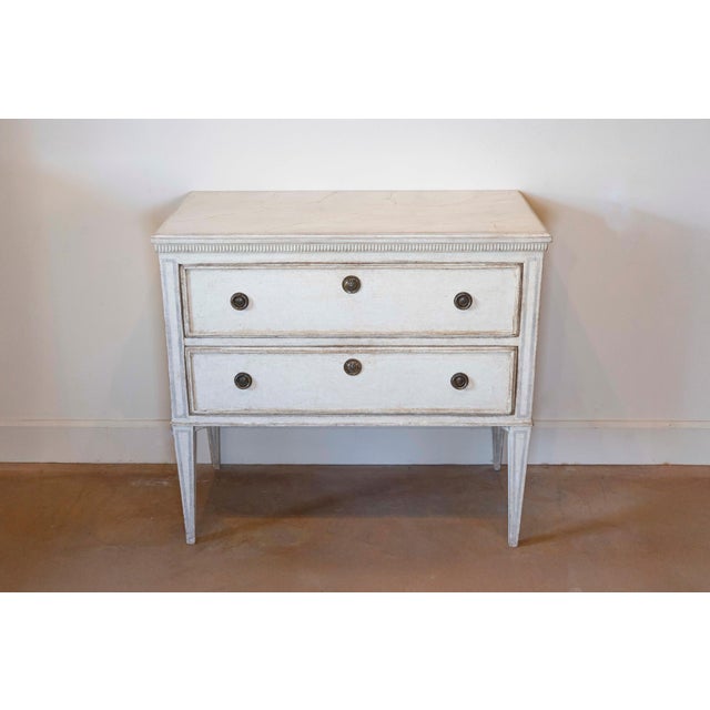 A Swedish Gustavian style painted chest circa 1890 with two drawers, carved fluted molding, light grey painted outlines...