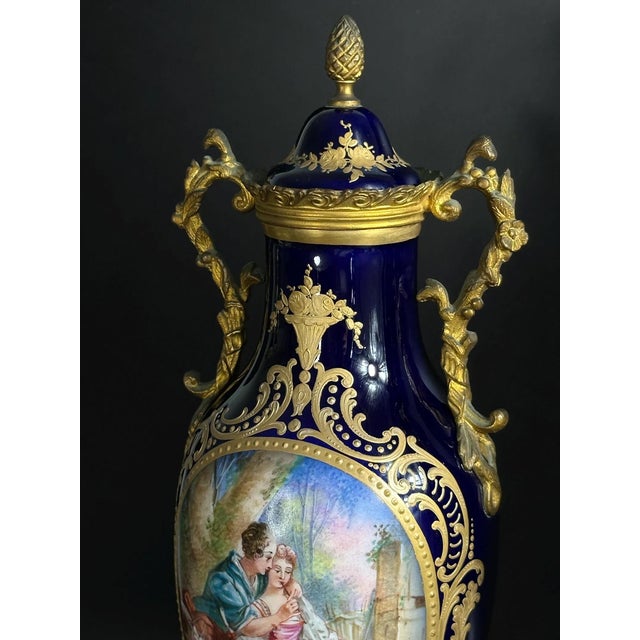 An exquisite pair of hand-painted porcelain vases of Sèvres, dating to the late 19th century. Each vase features a deep...