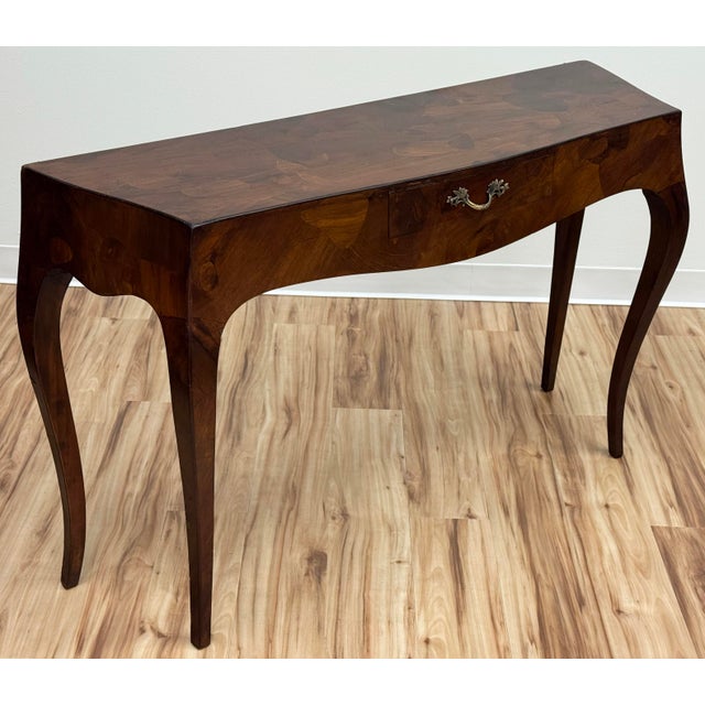 Console table or writing desk in Louis XVI style featuring graceful lines with a bowed tabletop and dramatic Saber legs....
