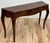 Console table or writing desk in Louis XVI style featuring graceful lines with a bowed tabletop and dramatic Saber legs....
