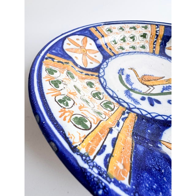 A beautifully hand-painted vintage Italian majolica plate, richly decorated in cobalt blue, ochre, and green. The center...