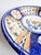 A beautifully hand-painted vintage Italian majolica plate, richly decorated in cobalt blue, ochre, and green. The center...