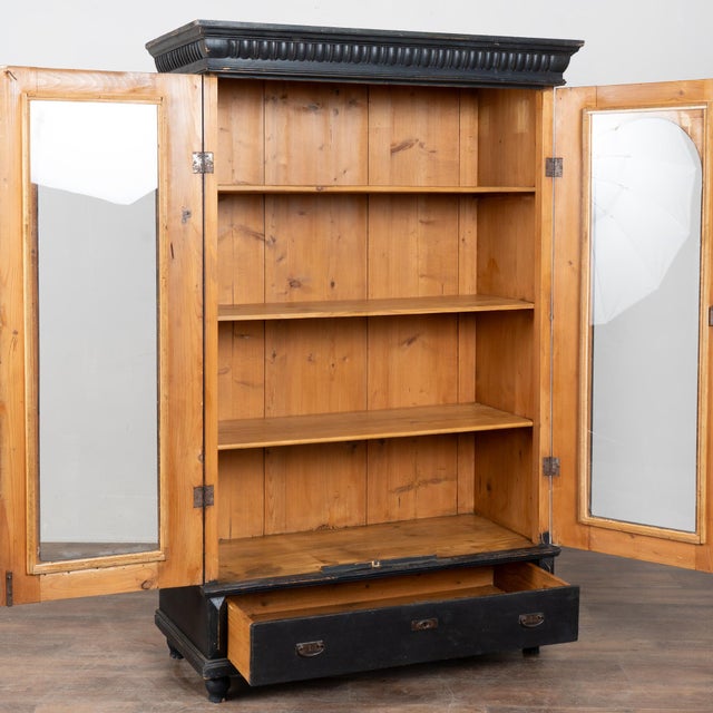 Early 20th-century Hungarian black painted display cabinet crafted in pine. The exterior features a newer black painted...