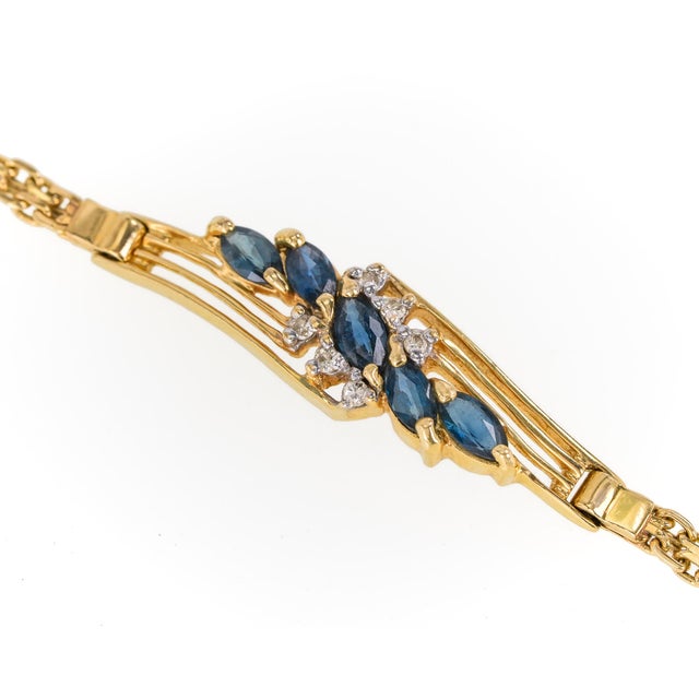 Vintage 14K yellow gold, sapphire and diamond bracelet, featuring a graceful openwork centerpiece set with blue marquise-...