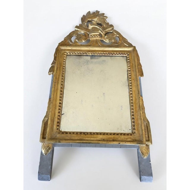 Small Louis XVI period mirror in carved and gilded wood. The pediment is openwork with a foliage design, and the frame is...