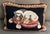 Needlepoint dog pillow of King Charles Spaniels. Mounted on black velvet back with self welt trim. Measures 13 3/4" across...