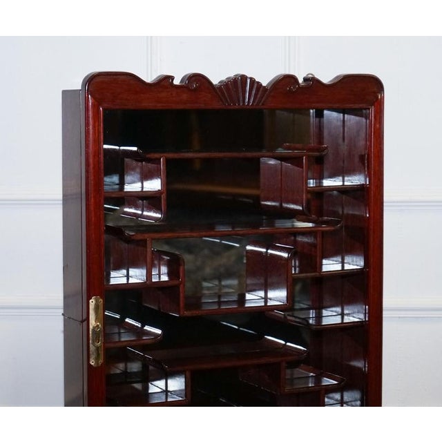 A decorative Asian-inspired display cabinet, suitable for either standing on a surface or mounting on the wall. The...