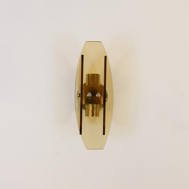 Pair of wall sconces by the Italian brand Veca. Manufactured in the 1970s from amber-brown Murano glass. Chrome-plated...