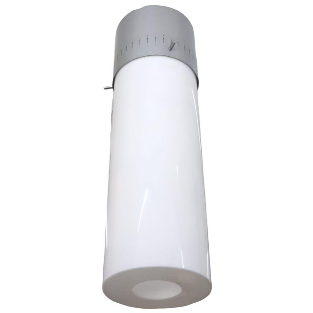 A unique 1958 Mid-century hanging lamp showcasing a vented aluminum cap and a white Lucite cylinder shade. This fixture...