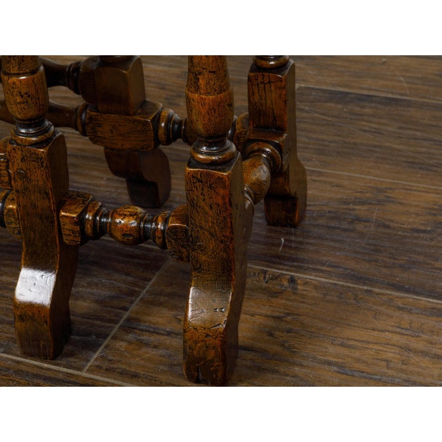 This petite 19th-century English oak gateleg table combines traditional craftsmanship with charming versatility, making it...